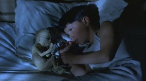 Seth confers with his "angel", a mummified baby discovered in the barn in Philip Ridley's The Reflecting Skin (1990)