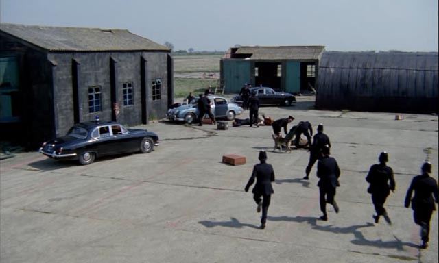 Police raid the gang's hideout in Peter Yates' Robbery (1967)