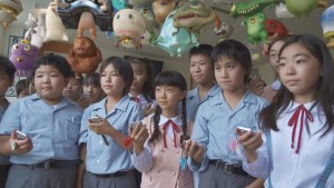 The kids using handheld devices to control their critters in Takashi Murakami's Jellyfish Eyes (2013)