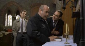 Father Michael Da Costa (Bob Hoskins) refuses to cooperate with the police in Mike Hodges' A Prayer for the Dying (1987)