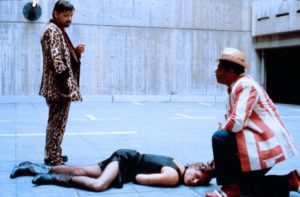 Jensen (Rainer Werner Fassbinder) and his sidekick Anton (Gunther Kaufmann) inspect a dead assassin in Wolf Gremm's Kamikaze '89 (1982)