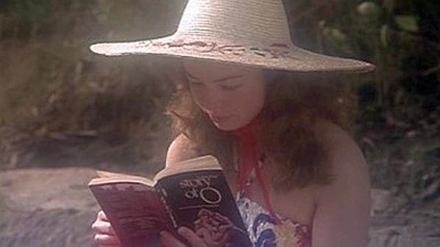 Felicity (Glory Annen) brushes up on what to expect in the Orient in John D. Lamond's soft-core travelogue Felicity (1978)