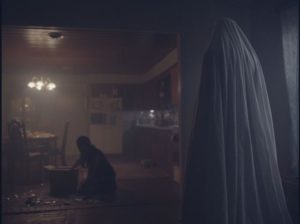 The ghost watches the house's new occupant clean up the mess he's made in David Lowery's A Ghost Story (2017)