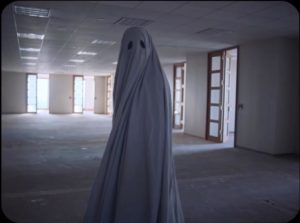 The ghost of C prowls through the building erected on the site of his demolished home in David Lowery's A Ghost Story (2017)