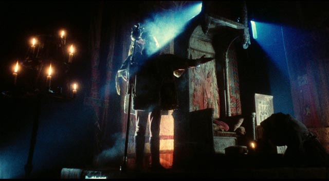 The herald (John Bird) announces the approach of the king in the throne room in Terry Gilliam's Jabberwocky (1977)