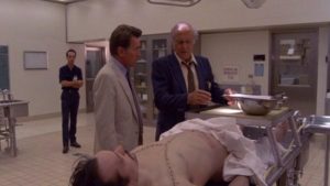 Cop Robert Loggia shows psychiatrist Martin Sheen what's been found in a dead man's belly in John Schlesinger's The Believers (1987)