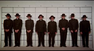 A police line-up, looking for a murderous priest in Mike Hodges' Pulp (1972)