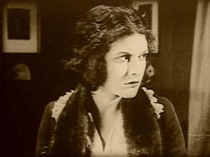 Nora (Evelyn Brent) realizes almost too late that she's in dire danger in Harry B. Parkinson's Trapped By the Mormons (1922)