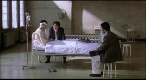Police interrogate a man who inexplicably murdered his wife after meeting Mamiya in Kiyoshi Kurosawa's Cure (1997)