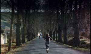 Estrella (Sonsoles Aranguren) runs to meet her father Agustin (Omero Antonutti) on his motorcycle in Victor Erice's El Sur (1983)