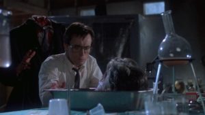 Herbert West (Jeffrey Combs) chats with the revived head of his academic nemesis in Stuart Gordon's Re-Animator (1985)