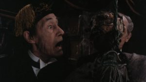 John Carradine receives a shock in Pete Walker's House of the Long Shadows (1983)