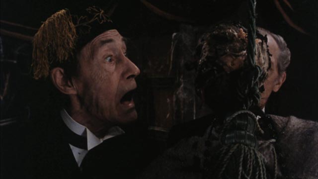 John Carradine receives a shock in Pete Walker's House of the Long Shadows (1983)