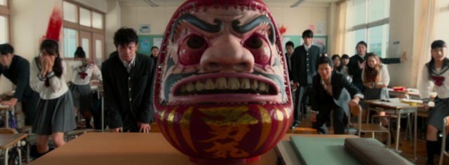 The deadly Daruma doll in the bloody opening scene of Takashi Miike's As the Gods Will (2014)