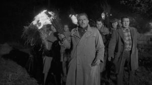 The villagers view the children with horror and form a traditional torch-wielding mob in Wolf Rilla's Village of the Damned (1960)