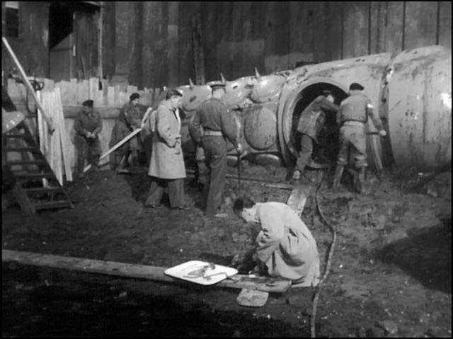 Quatermass and Colonel Breen inspect the ancient crash site in Quatermass and the Pit (1944)