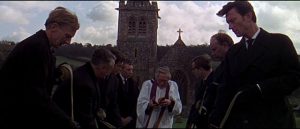 Alexander Eberlin (Laurence Harvey) attends the funeral of a fellow spy in Anthony Mann's A Dandy in Aspic (1968)