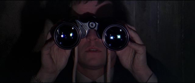 British agent Gatiss (Tom Courtenay) spies on fellow spy Eberlin (Laurence Harvey) in Anthony Mann's A Dandy in Aspic (1968)