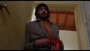 George Eastman arrives unexpectledy at a suburban home somewhere in America in Joe D'Amato's Absurd (1981)