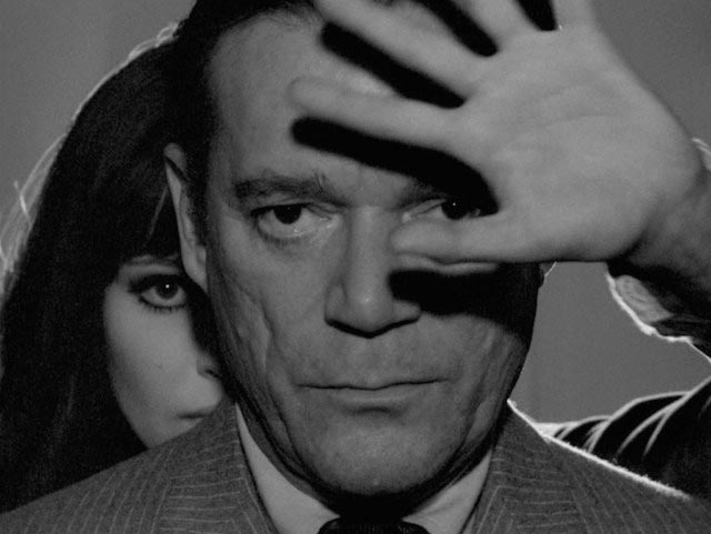 Lemmy Caution (Eddie Constantine) and Natacha von Braun (Anna Karina) confront a super-computer in Jean-Luc Godard's Alphaville (1965)