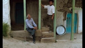 Hossein (Hossein Rezai) and the Director-character (Farhad Kheradmand) listen to the Director's instructions between takes in Abbas Kiarostami's Through the Olive Trees (1994)