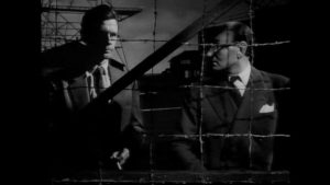 Heathley (James Donald) and project head Professor Carrington (Maurice Denham) disagree on the risks of a test flight in Anthony Asquith's The Net (1953)