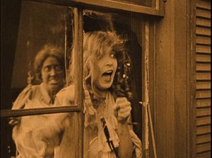 Elsie Stoneman (Lillian Gish) watches horrified as Free Blacks rampage in the streets in D.W. Griffith's Birth of a Nation (1915)