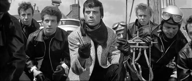 King (Oliver Reed) and his leather gang menace an American tourist in Joseph Losey's The Damned (1962)