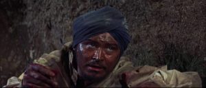 Dying Lt. Case (Ronald Lewis) crawls over jagged rocks towards the woman he loves in John Gilling's The Brigand of Kandahar (1965)