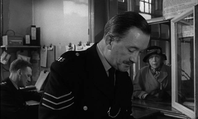 A patient policeman (Jack Austin) reassures Mrs Ross (Edith Evans) that her fears are taken seriously in Bryan Forbes' The Whisperers (1967)