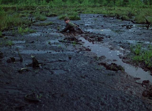 Flyora (Alexei Kravchenko) wades through a bog searching for his family in Elem Klimov's Come and See (1985)