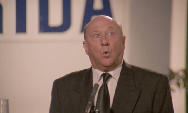 Reverend Mortom (Donald Pleasence) loses control of his mouth at an awkward time in Sergio Martino's American Rickshaw (1989)