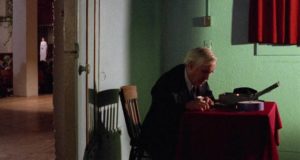 Walter Travis (Jason Robards) counts cash while daughter Martha (Rosanna Arquette) offers her visions to the congregation in Mike Hodges' Black Rainbow (1989)
