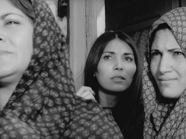 Seamstress Ati (Parvaneh Massoumi) watches the new teacher's arrival in Bahram Beyzaie's Downpour (1972)