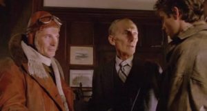 The Commodore (Peter Cushing) explains a vital mission to Biggles (Neil Dickson) and Jim Ferguson (Alex Hyde-White) in John Hough's Biggles: Adventures in Time (1986)