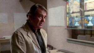 Former rugged leading man Stuart Whitman as Father Cunningham, a weary priest fighting evil in Alfredo Zacarias' Demonoid (1981)