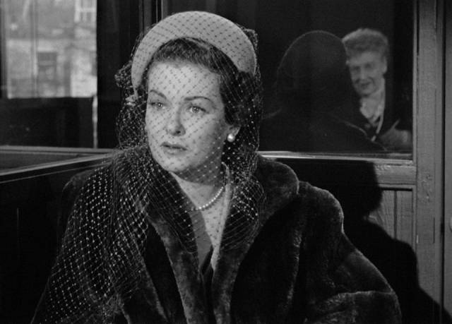 Trying to raise money, Lucia (Joan Bennett) is asked awkward questions at a no-questions-asked loan company in Max Ophuls' The Reckless Moment (1949)
