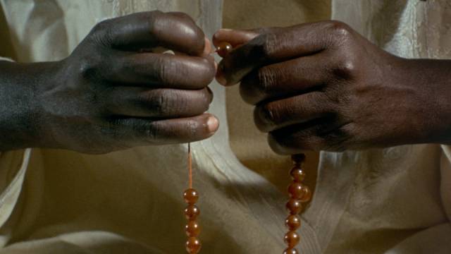Ibrahim (Makhouredia Gueye) gets comfort from the formal trappings of religion in Ousmane Sembene's Mandabi (1968)