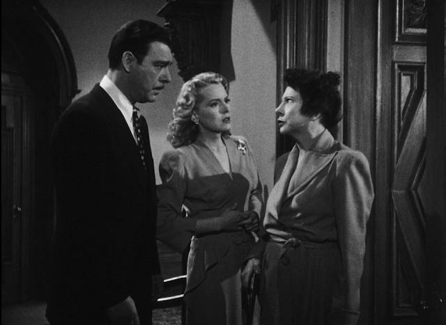 Wayne Fletcher (Chaney) and Donna Kincaid (Brenda Joyce) are confronted by eccentric Amelia Kincaid (Rosalind Ivan) in Wallace Fox's Pillow of Death (1945)