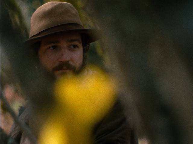 Cookie (John Magaro) counters the harshness of the frontier by baking in Kelly Reichardt's First Cow (2020) 