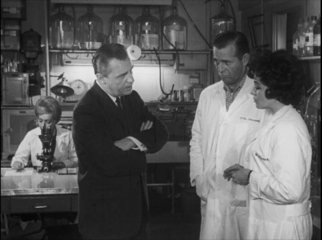 A government agent seeks answers from baffled scientists in Bill Rebane and Herschell Gordon Lewis’s Monster a Go-Go (1965)