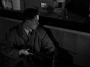 Edward Miller (Arthur Franz) waits for Jean Darr (Marie Windsor) on a rooftop with his rifle in Edward Dmytryk's The Sniper (1952)