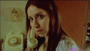 Altair (Diana Bovio) answers a vaguely menacing phone call in Victor Dryere’s 1974: La posesión de Altair (2016)