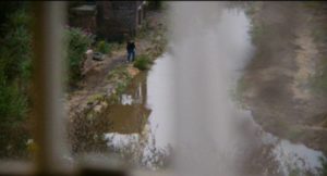 James (William Eadie) plays at the edge of the filthy canal in Lynne Ramsay's Ratcatcher (1999)