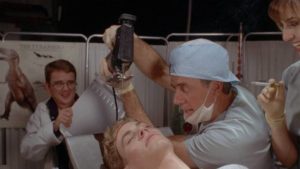 Wacky Dr. Wachenstein (Terry Kiser) performs some unorthodox surgery in Stewart Raffill's Tammy and the T-Rex (1994)