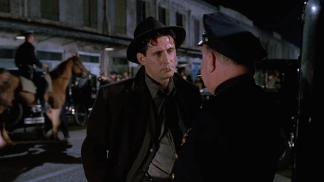 Tom Reagan (Gabriel Byrne) chats with police chief O'Doole (Tom Toner) outside a club being raided in the Coen Brothers' Miller's Crossing (1990)