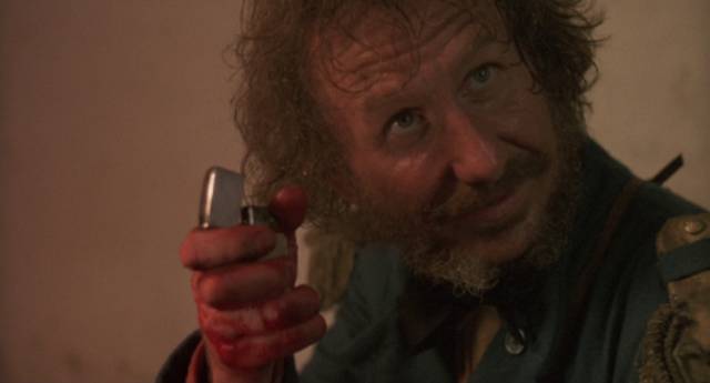 Major Hennington (Rene Auberjonois) pulls out a Zippo lighter to ignite a fuse in Alex Cox's Walker (1987)