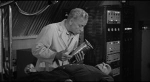 Dr. Peter Ulof (Ivan Triesault) assures Joey Faust (Douglas Kennedy) that it won't hurt a bit in Edgar G. Ulmer's The Amazing Transparent Man (1960)