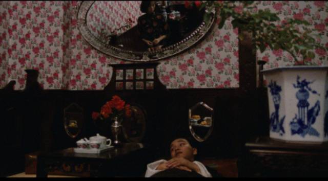 Chan (Leslie Chueng)'s courting of Fleur (Anita Mui) is a mixture of grand gestures and passive waiting in Stanley Kwan's Rouge (1987)