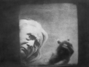 The blood-drinking witch (Henriette Gérard) peers into hero Allan Gray (Nicholas de Gunzburg)'s coffin in Carl Th. Dreyer's Vampyr (1932)